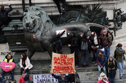 Los manifestantes se acercan y cuelgan carteles en uno de los leones de la plaza de la República en París, durante una nueva jornada de manifestaciones.