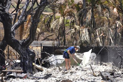 Una mujer cava entre los escombros de una casa destruida por el incendio forestal, este viernes 11 de agosto, en Lahaina (Hawái). 
